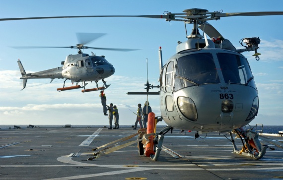 During Exercise RIMPAC 2006, a Squirrel sits ready for flight as personnel are winched into HMAS Manoora's second Squirrel.