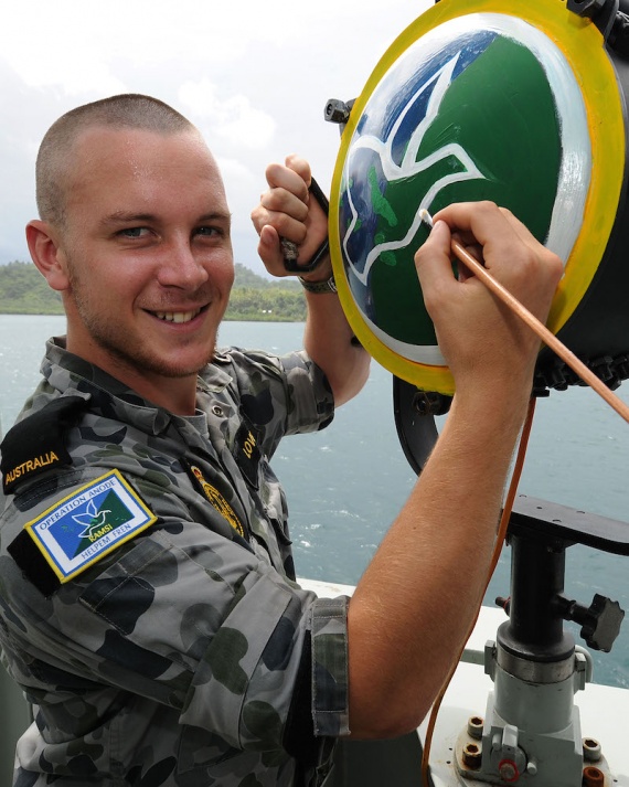  Seaman Nicolas Love paints the back of the ten inch light with the RAMSI logo during HMAS Brunei's deployment in the Solomon Islands in 2010