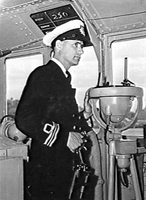 Lieutenant Commander Neville Pixley, MBE, RANR, Commanding Ofiicer of HMAS Bundaberg on the bridge of his command.