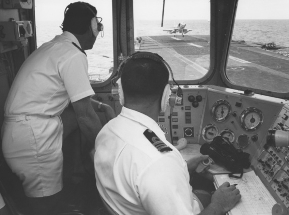 Commander Ken Douglas and Lieutenant Commander Graham Rohrsheim in Flight Control (FLYCO) watch a Skyhawk landing.