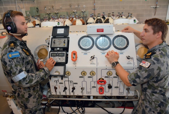 Sailors man the control panel of the recompression chamber at HMAS Penguin.