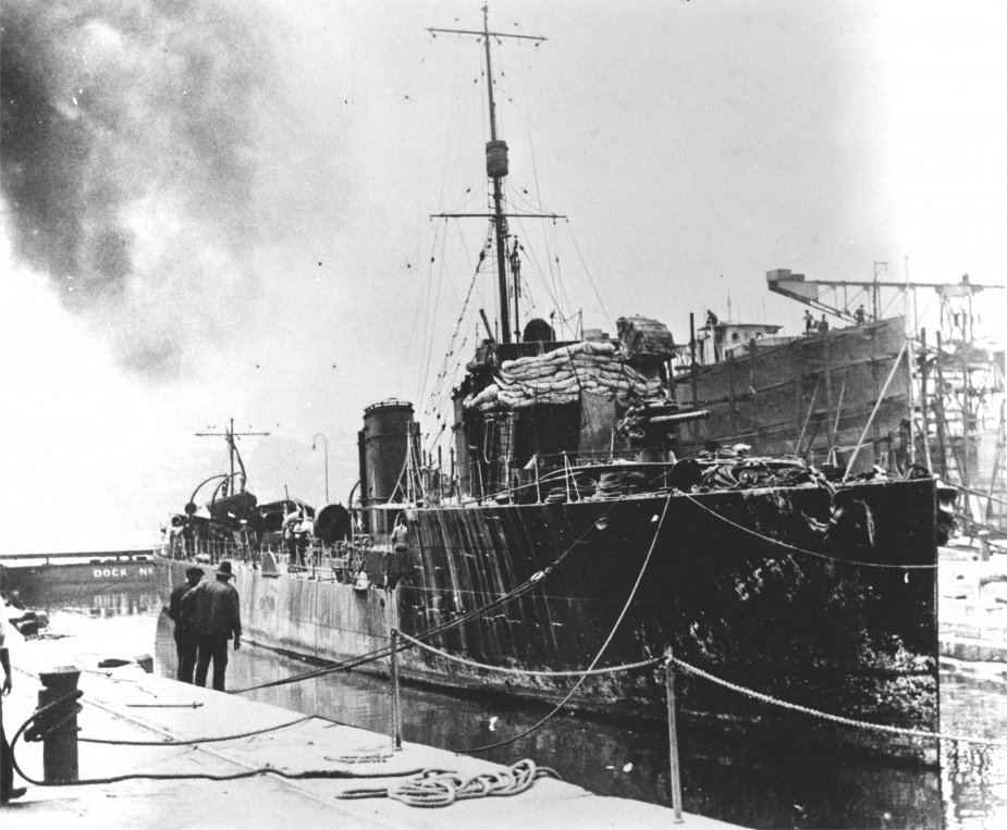 Painted black and with splinter mats fixed to her forward superstructure, HMAS Warrego (I) docks at Cockatoo Island on her return from the successful operation to seize German possession in New Guinea.