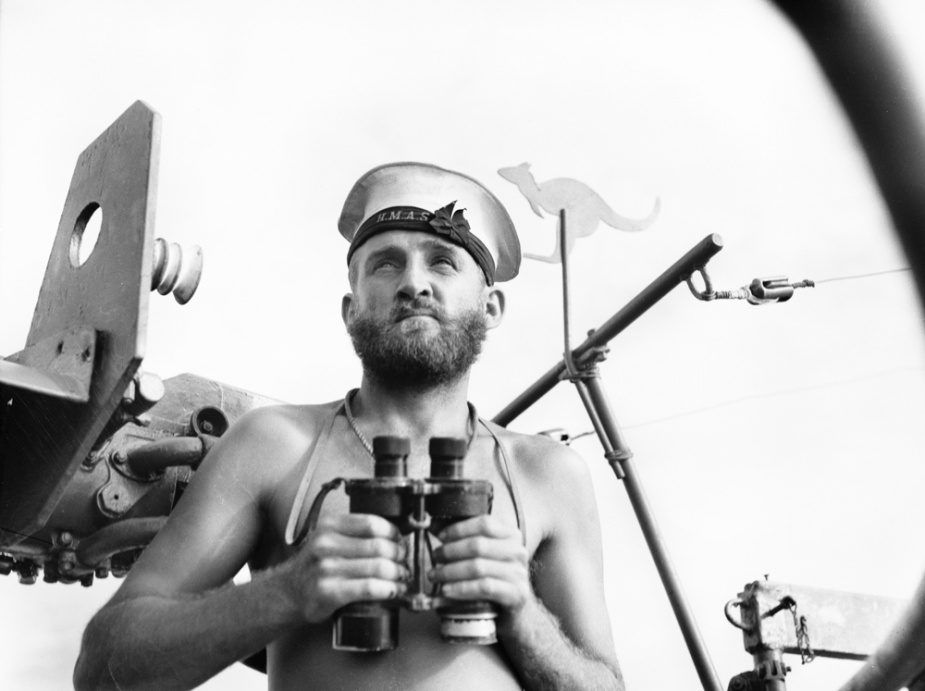 Able Seaman J Conway on watch in ML 802, Jacquinot Bay, New Guinea, 28 January 1945. Note the kangaroo cut-out attached above the gun mount. (AWM 078677)