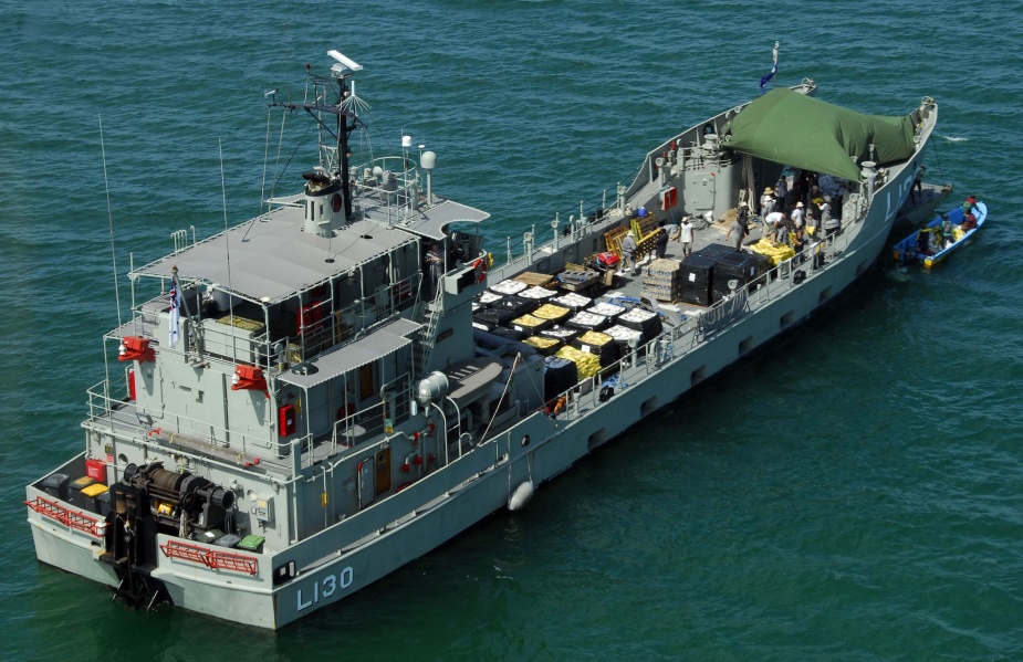 HMAS Wewak, sits off the coast at Gona Beach in Papua New Guinea, with a load of food, water and medical aid assistance to be moved out by small craft During Operation PNG Assist. 