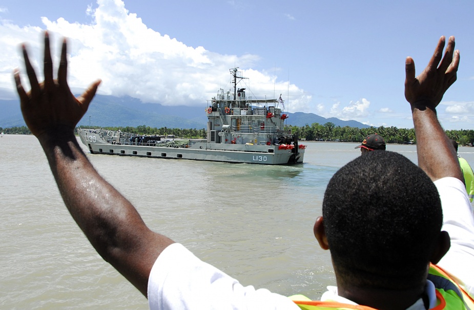 A local Papua New Guinean man who helped load aid for villages affected by floods after Cyclone Guba waves goodbye to Royal Australian Navy Landing Craft Heavy HMAS Wewak from Lae port, in Papua New Guinea during Operation PNG Assist.