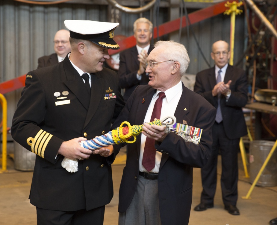 Commanding Officer NUSHIP Canberra, Captain Jonathan Sadleir with Mr David Morse presenting the ship's bell rope during the NUSHIP Canberra acceptance celebration on 7 October 2014.