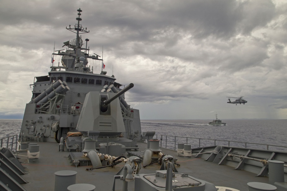 FSS Independence steams alongside HMAS Parramatta as HMAS Parramatta's embarked MH-60R Helicopter 'Warlock' flies between the two ships in the waters of Yap, Micronesia.