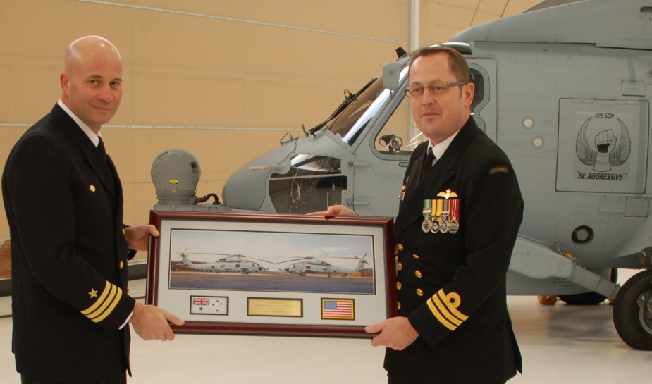 NUSQN 725 Commanding Officer, Commander David Frost, presents a commemorative plaque to NAS Jacksonville’s Center for Naval Aviation Technical Training Unit Commanding Officer, Commander Edgar Twining, in appreciation of the Unit’s training efforts. (Photo courtesy Jax Air News)
