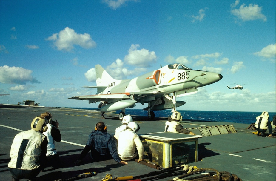 An 805 Squadron Skyhawk on HMAS Melbourne's catapult prepares to launch. The deck crew in the foreground are just part of the team that work in often extreme conditions to keep aircraft flying.