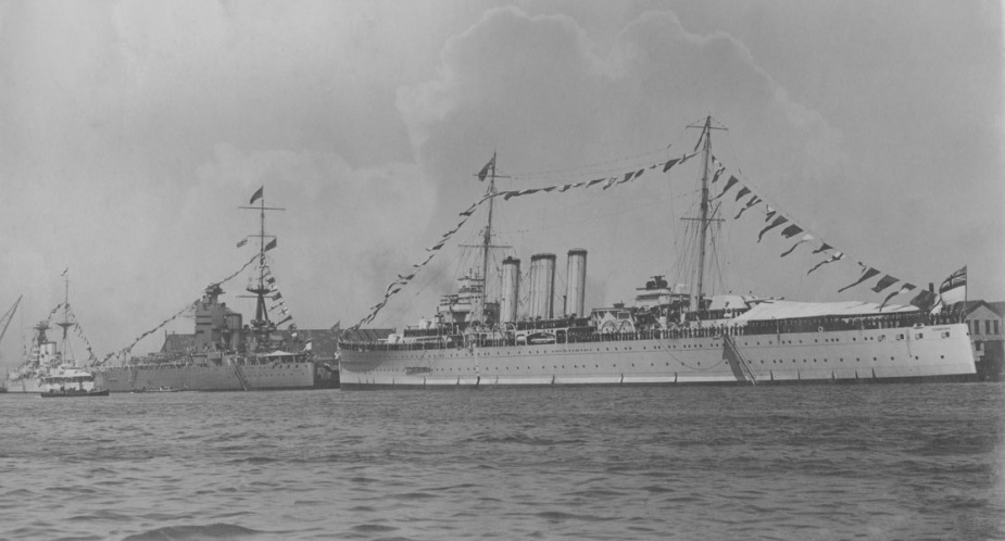 HMAS Canberra (I) astern of the Royal Navy battleship HMS Nelson, on the occasion of a visit by King George V to Portsmouth Dockyard on 17 July 1928. The ships were dressed overall to commemorate the event and the King later went on board the recently commissioned Canberra to review her ship's company. (Ken Cartwright Collection)