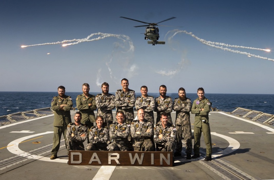 HMAS Darwin's Aviation department with the embarked helicopter, 'Blackout', an S-70B Seahawk, deploying flares in the background. 