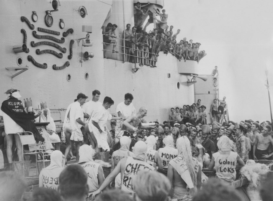 Members of HMAS Vengeance watch on as a pollywog is welcomed into the ancient order of the deep. 3rd November 1954