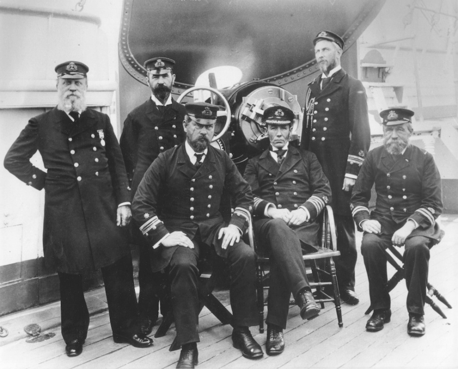 Officers of HMCS Protector, 14 September 1897, in front of one of the ship's 6-inch guns. Standing from left: Warrant Officer James White, Chief Gunner Edwin Argent, Lieutenant Patrick Weir; Seated: Chief Engineer William Clarkson, Captain William Creswell and Lieutenant Marshall Smith.