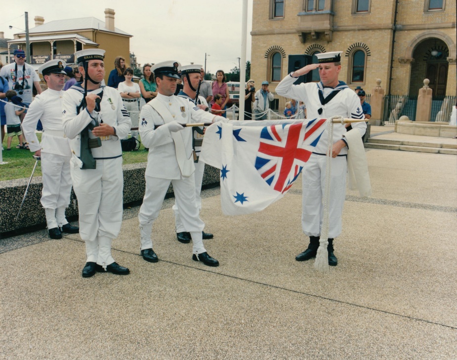 Petty Officer Signals Yeoman Gary Swanton unfurls the Australian White Ensign prior to the crew of HMAS Newcastle exercising its right to Freedom of Entry into the City of Newcastle, NSW.