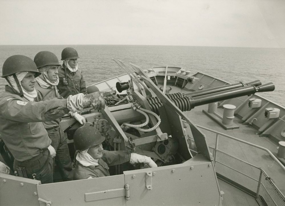 Petty Officer Laurie Nicholson points out attacking 'enemy' aircraft to Stalwart's M1 gun crew: L-R Able Seaman Glenn Gill, Able Seaman Edward Andrew and Able Seaman Bruce Meyer