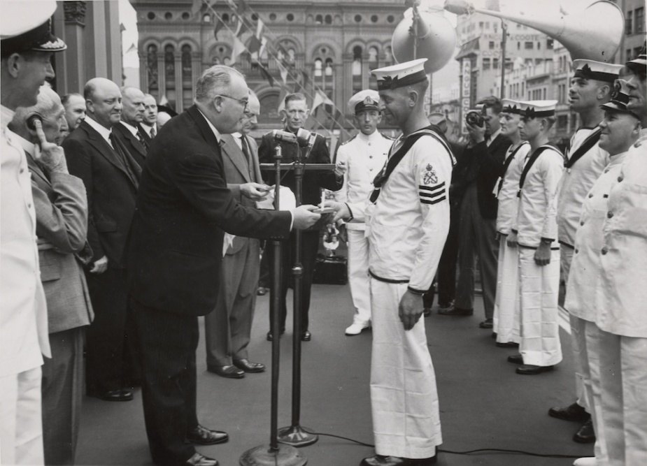 The Lord Mayor of the City of Sydney presents one of HMAS Sydney's petty officers with a medallion commemorating the victory over Bartolomeo Colleoni