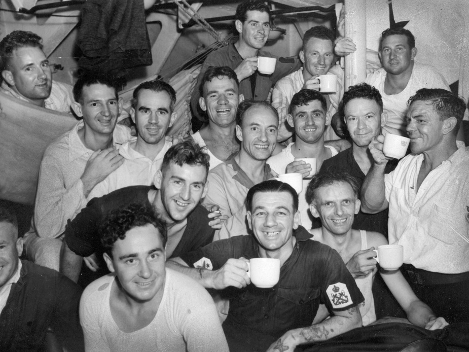 A group shot of some of Sydney's petty officers. Identified in this photo are: Left rear: Petty Officer Henry Briggs, Left front: Petty Officer George Berry, Centre front: Petty Officer Bill Aylott. Front right standing: Petty Officer Otto Smith, Right rear: Petty Officer Oliver Webb. Petty Officer Richard Curtis can be seen at the rear 4th from the left.