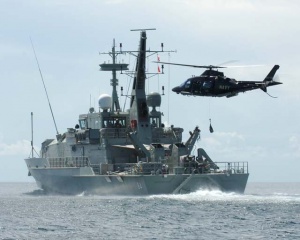 RAN Agusta Westland A109E above HMAS Larrakia.