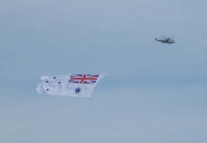 RAN Sea King flies the White Ensign at the HMAS Albatross 60th Anniversary Air Show.