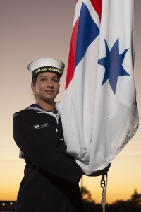 Seaman Paige Blake prepares to raise the Australian White Ensign in preparation for the commissioning of HMAS Moreton in Brisbane Queensland. (ABIS Steven Thomson)