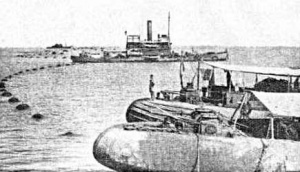 HMAS Koompartoo western gate vessel. In foreground, stern of HMAS Kara Kara with BWV alongside. (The Sun, 2 August 1943. Courtesy of the Herald & Weekly Times Pty Ltd)