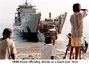 HMAS Brunei offloading vehicles on a beach, East Timor