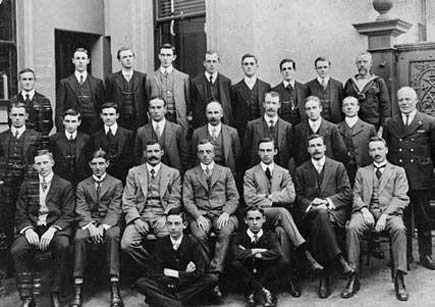 Group portrait of office staff of the central administration, Department of the Navy, outside the Lonsdale Street building Melbourne, Vic. July 1912. Left to Right, Back Row: Mr A. Holmes, Mr R.A. Ball, Mr Thomas, Mr C. Massey, Mr W.R. Cox, Mr R. Barwell, Mr P. Tierney, Mr A.E. Veitch, Seaman Carpenter (Messenger). Middle Row: Mr Davies, Mr G.N.P. Watt, Mr A. Wingfield, Mr R. Abercrombe, Mr Robinson, Mr G. Sharp, Mr J.D. Jackson, Mr Newman, Chief Petty Officer P. Shenn. Front Row: Mr D. O'donoghue, Mr C. Wo