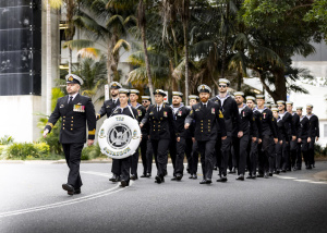 Lieutenant Commander Michael Cairncross leads personnel from 725 Squadron through the streets of Coffs Harbour during the Anzac Day 2024 march.