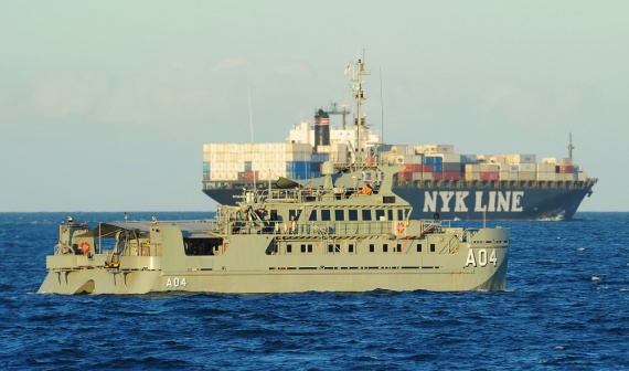 HMAS Benalla transits down the North Queensland coast while being passed by a large merchant ship during the Minor War Vessel Concentration Period from 30 May to 3 June 2011 in waters off Cairns.