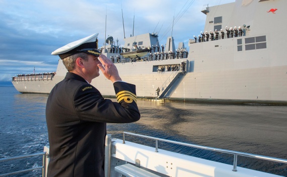 Commanding Officer HMAS Sydney, Commander Edward Seymour, RAN salutes his crew inside Jervis Bay, NSW following the ship's commissioning ceremony at sea on 18 May 2020..