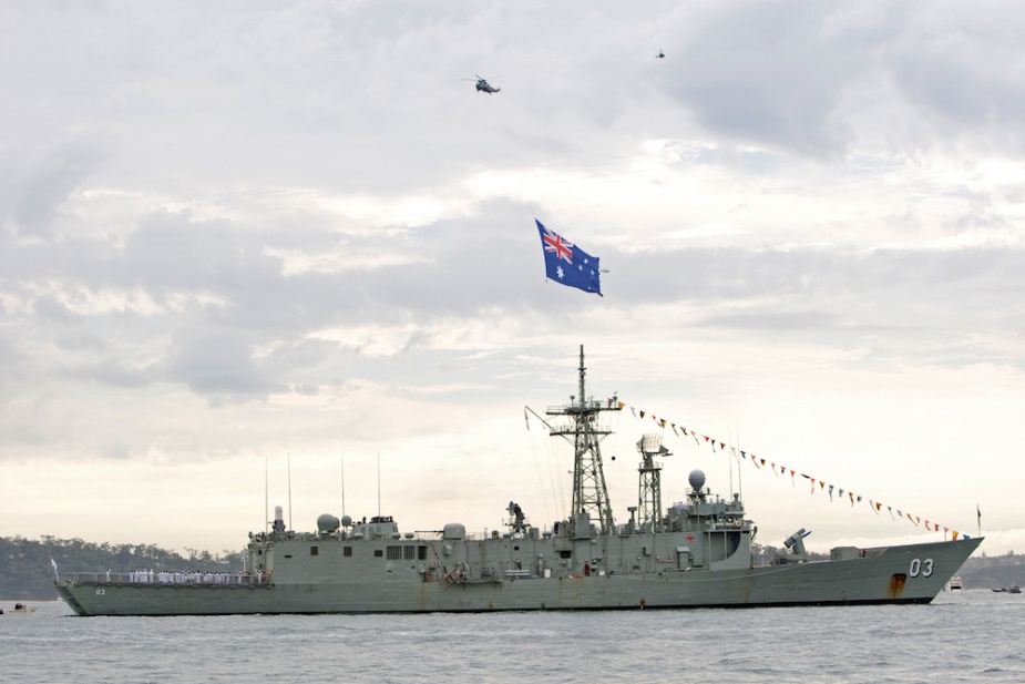 A Sea King helicopter from 817 Squadron flying the Australian National Flag over HMAS Sydney (IV) during the Royal Australian Navy’s Fleet Review in 2009.