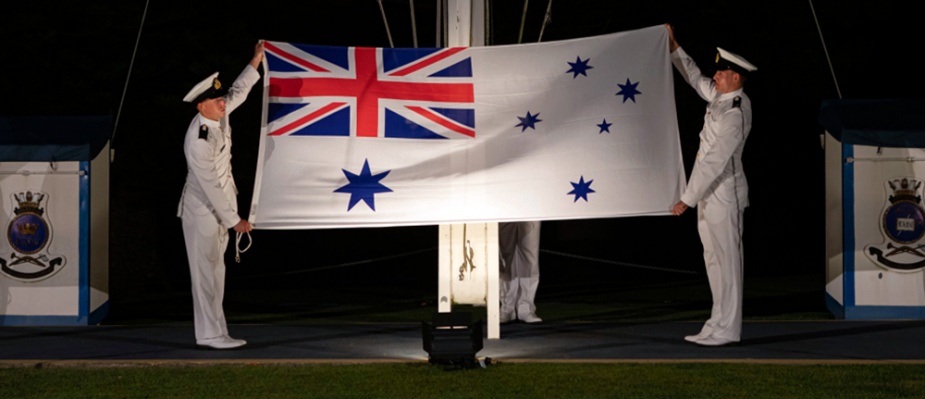 Royal Australian Navy New Entry Officers lower the Australian White Ensign during a Ceremonial Sunset Parade at HMAS Creswell, Jervis Bay, November 2020.