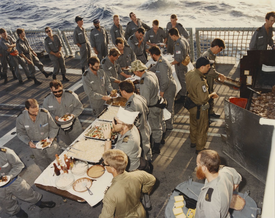 Members of the crew enjoy a 'steel deck' barbeque, a welcome moment of respite during a high tempo operational period. December 1992.