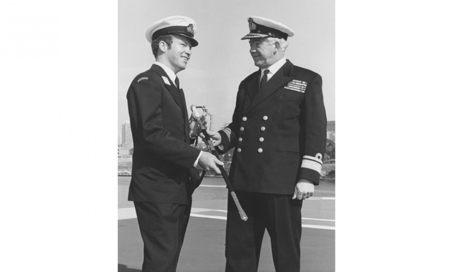 “The young and the old”. Rear Admiral William Dovers congratulates his son Midshipman Dovers on his award of the RAN College Jubilee Memoral Sword on the flight deck of HMAS Melbourne in 1972.