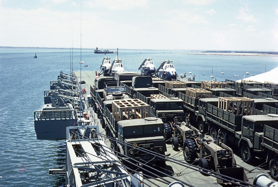 Sydney's deck crowded with cargo. Note the LCM 6 landing craft secured outboard.
