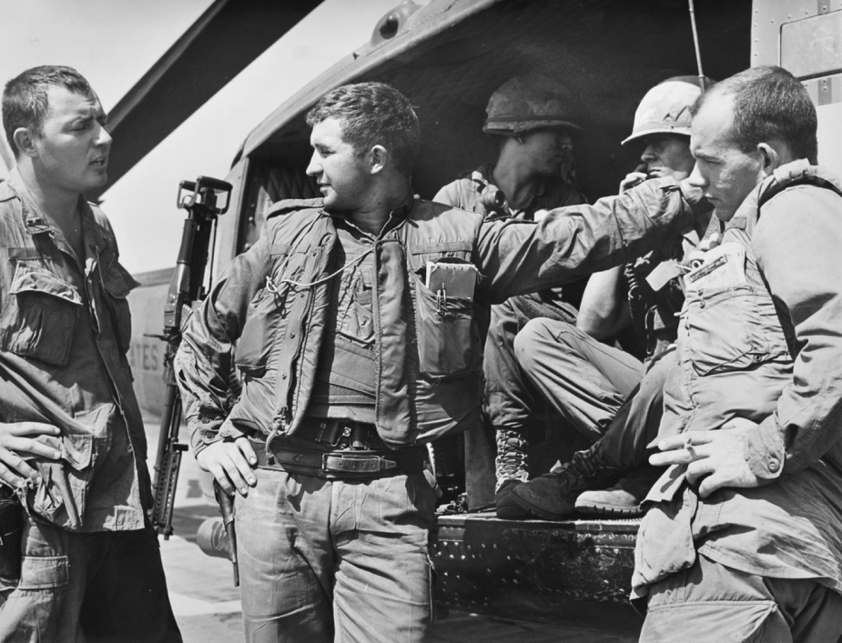 Jeff, second from lift, in discussion with US Army personnel beside a UH-1H 'Slick'. 