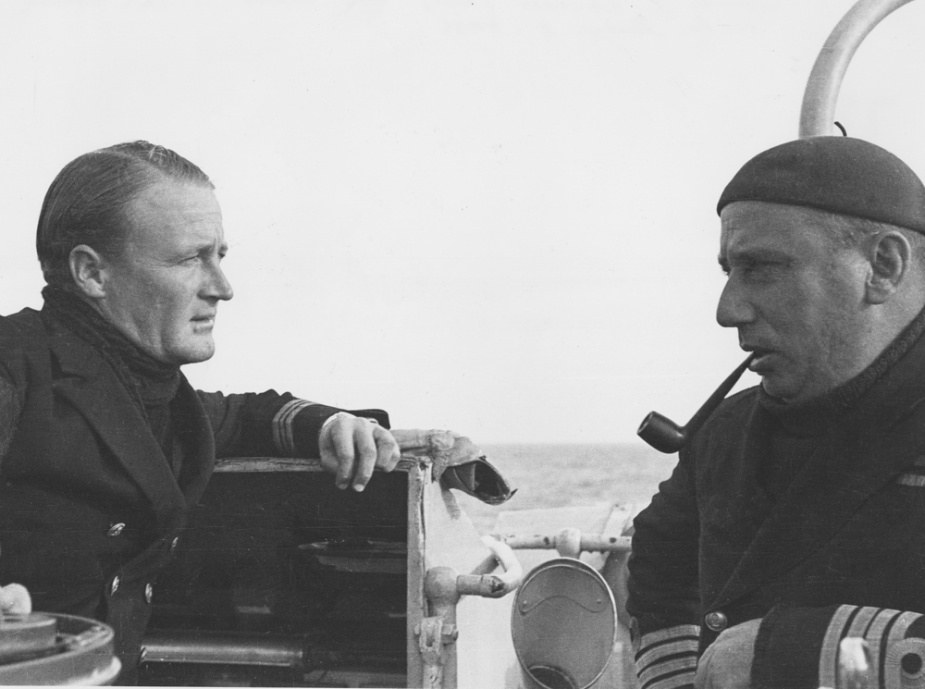 Lieutenant Commander R Rhoades confers with Captain Waller at sea in the Mediterranean.