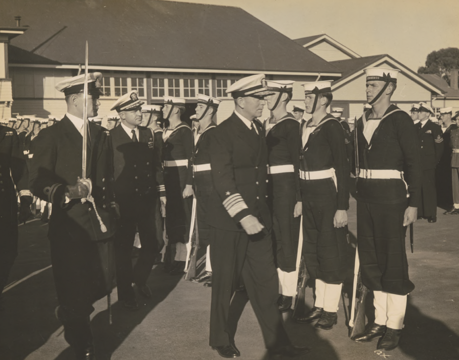 Lieutenant Robertson (with sword) accompanies the United States Chief of Naval Operations, Admiral Forrest Sherman during an inspection of the HMAS Cerberus Gunnery school, circa 1950. (Robertson Collection)