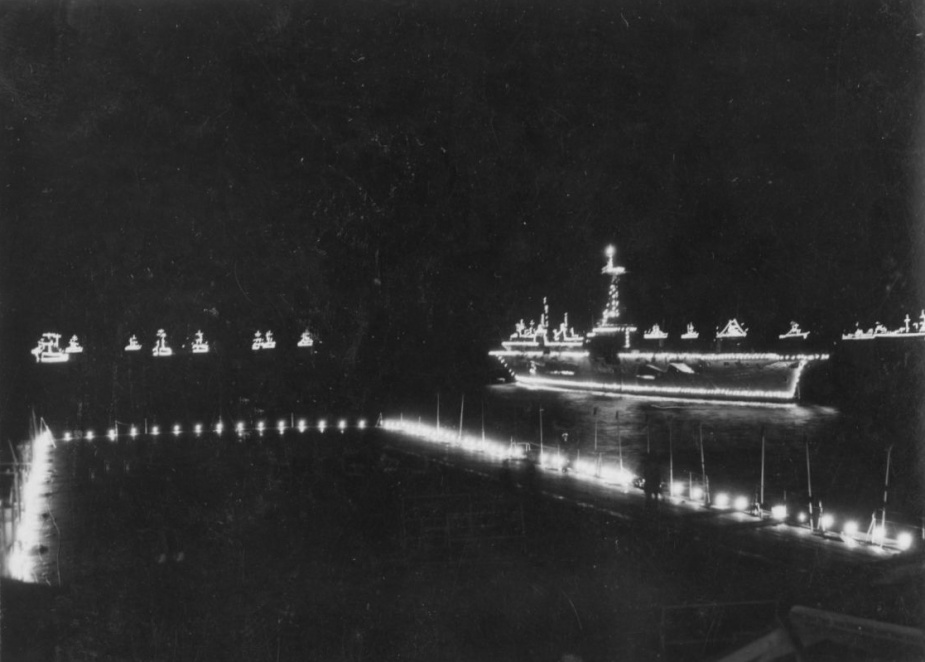 The coronation fleet illuminated with festoon lighting as seen from Sydney's island.