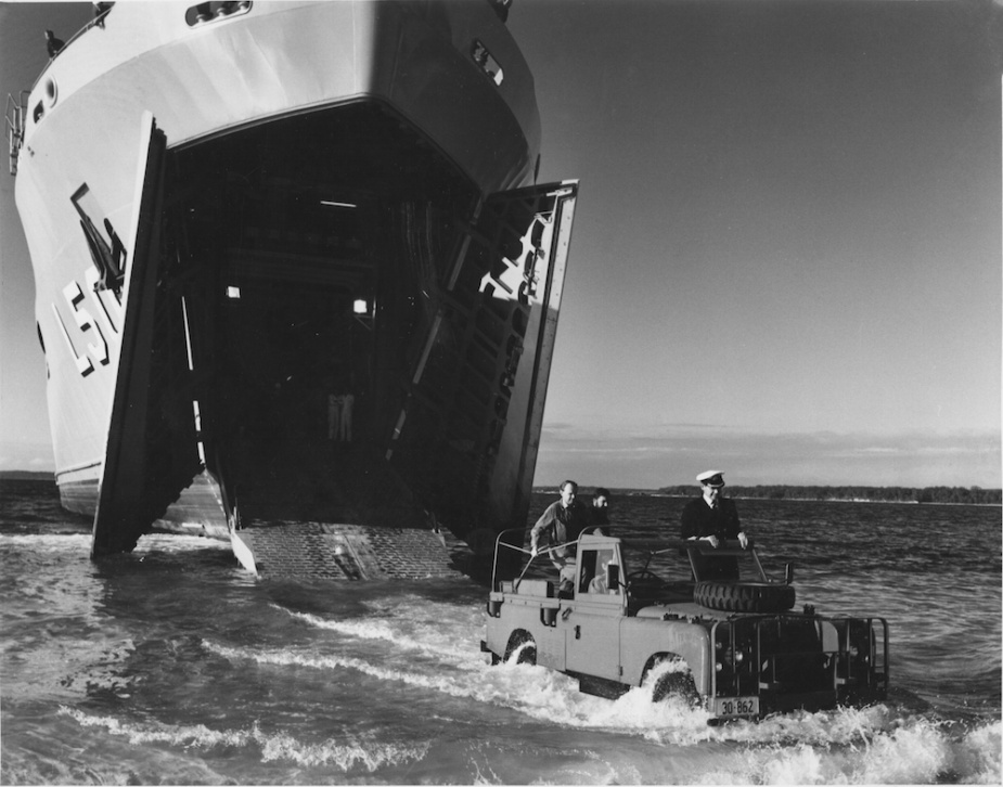 First beaching test of the ship since it was commissioned. Tobruk, beached in Jervis Bay, the bow doors are opened and the ramp lowered  to allow the ship's vehicle to make its first 'wet run' ashore. Captain Doolan was joined in the vehicle by the Officer-in-Charge of the ship's Army detachment, Major Charles Gillman-Wells. 