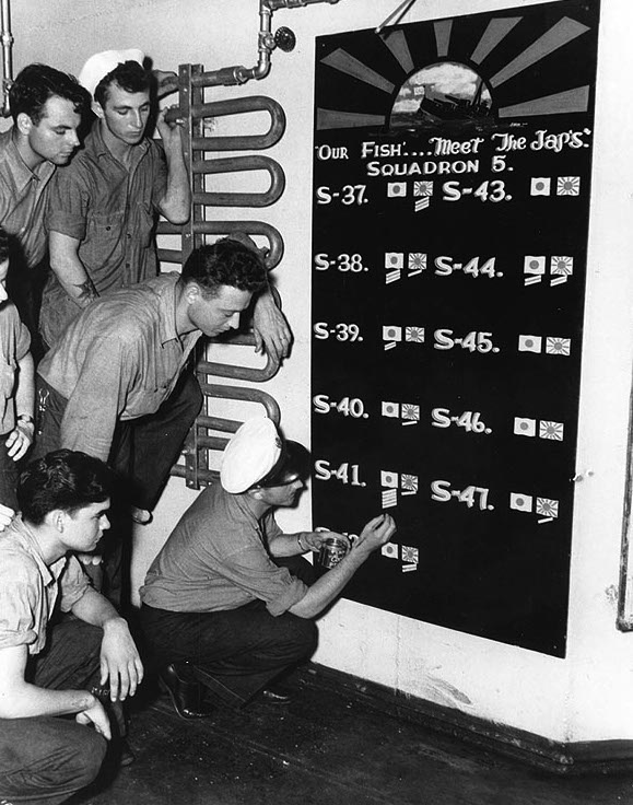 Sailors in the submarine tender USS Griffin update Submarine Squadron 5's scoreboard (USN #80-G-77065)