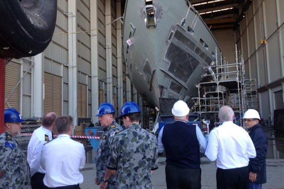 Chief of Navy, Vice Admiral Tim Barrett (third from left) inspects the hull of the fire damaged Armidale Class Patrol Boat HMAS Bundaberg at a Brisbane dockyard.