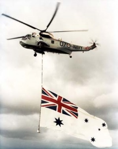 A RAN Sea King flies the White Ensign.